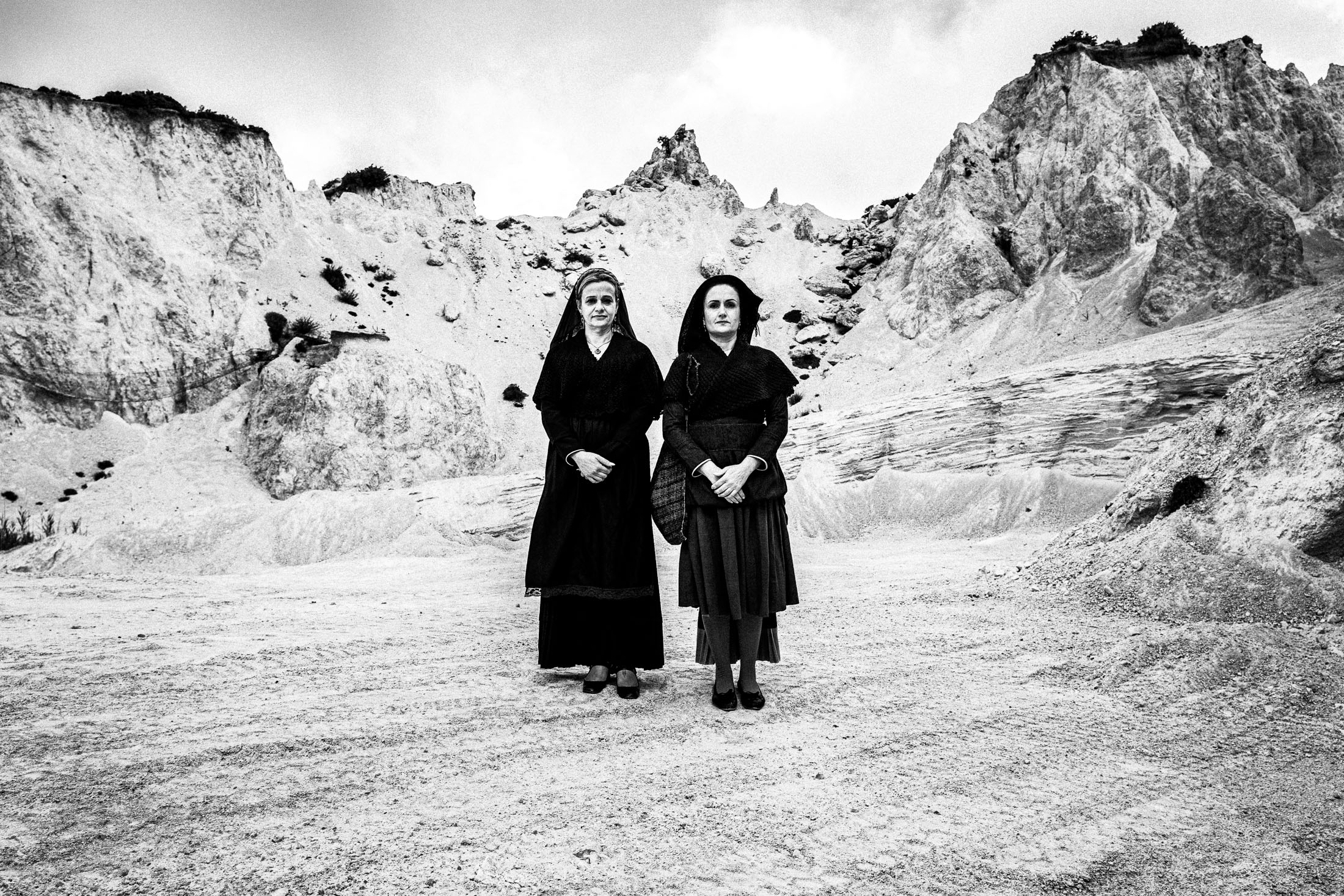 Women wearing the local costumes of Lefkada in the Ionian, standing at local white cliffs
