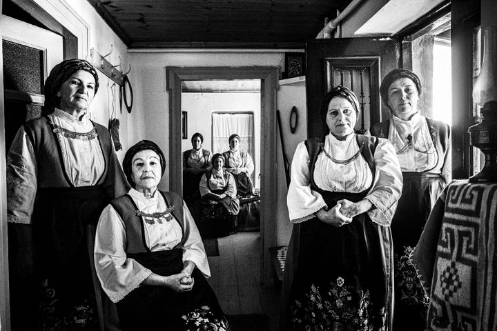 A group of women wearing the costumes of Ypati, inside a local house