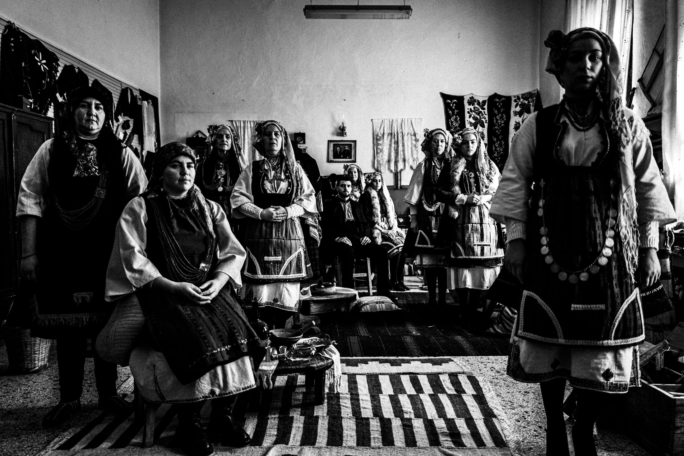A group of people wearing the local costumes of Skopos in Florina, inside a local school that also serves as a folklore museum