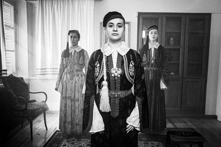 Women wearing the urban dresses of Ioannina Epirus, standing inside a local mansion