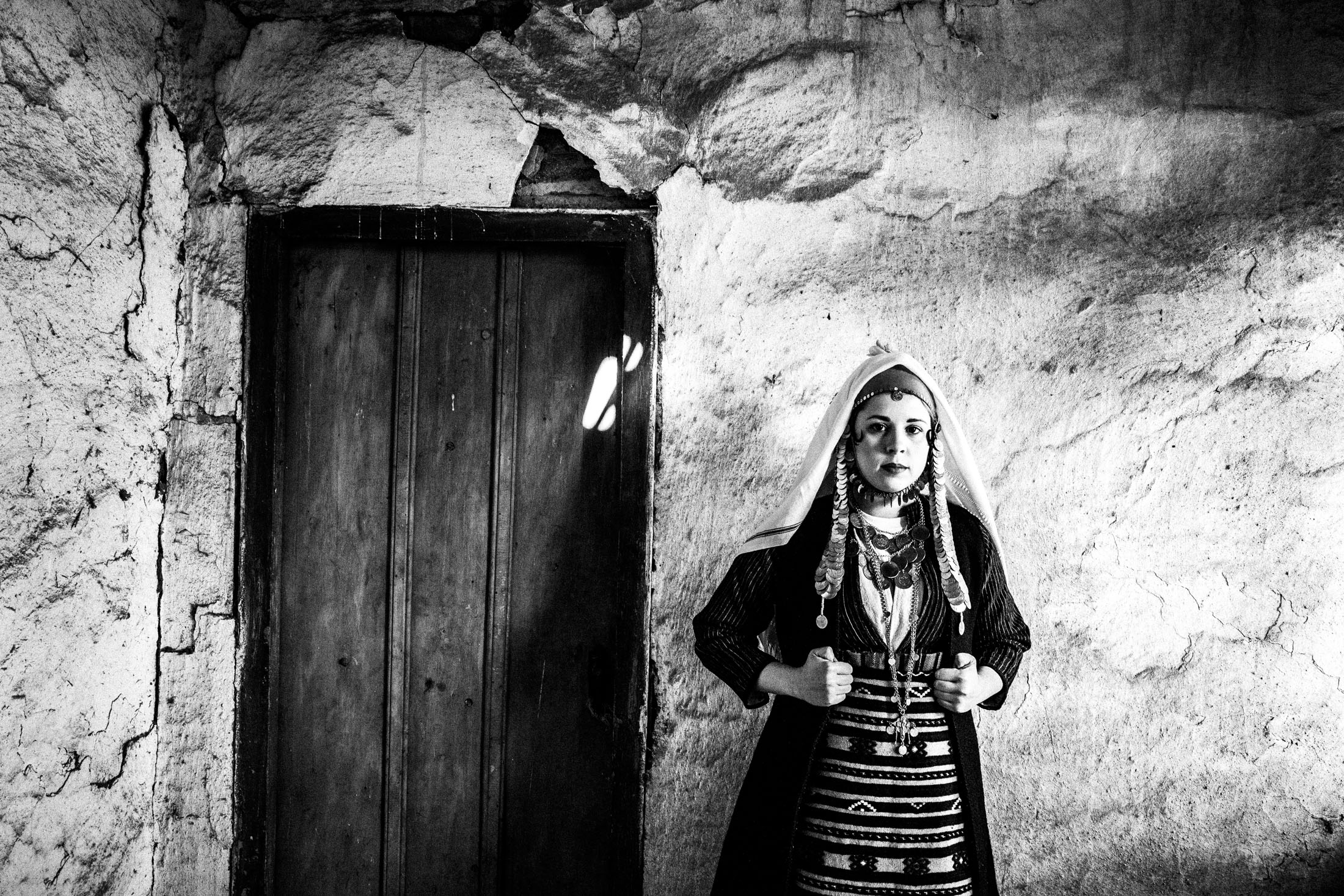 A woman weating the local costume of Isaakion in Evros, Thrace posing inside a local house
