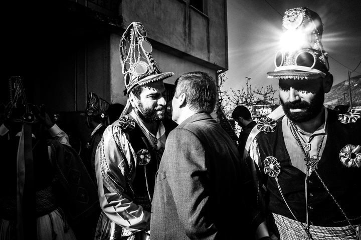 Kotsamania dancers greeting a resident during the house-to-house procession.
