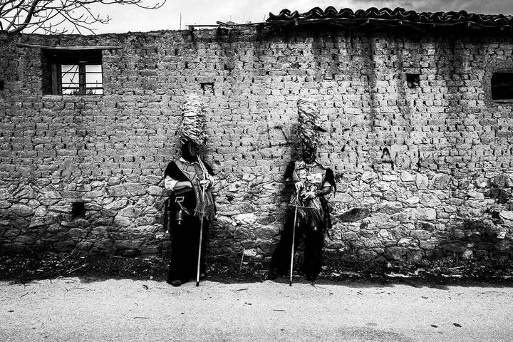 Bell-bearers against a wall during the carnival of Profitis, Macedonia