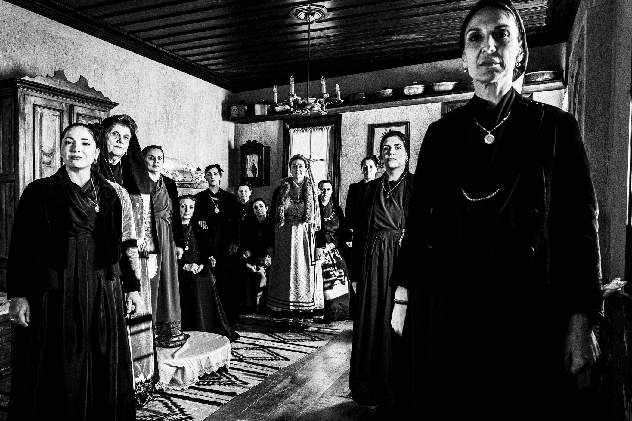 Women wearing the traditional local dress of Sohos inside a village house.