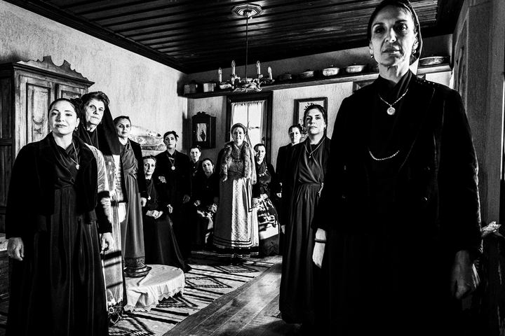 Women wearing the traditional local dress of Sohos inside a village house.