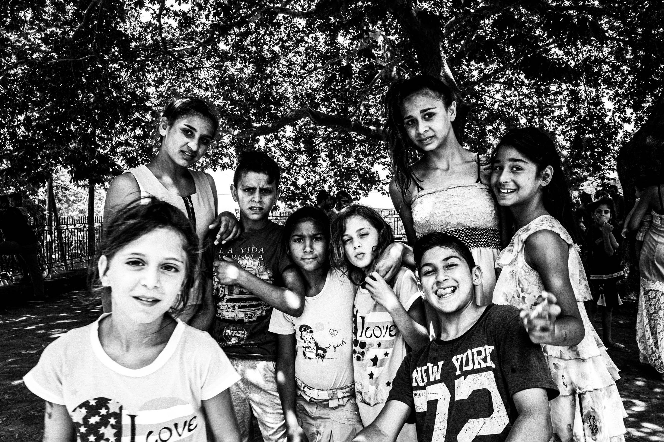 A group of Roma children gathered beneath the trees outside Saint Simeon church.
