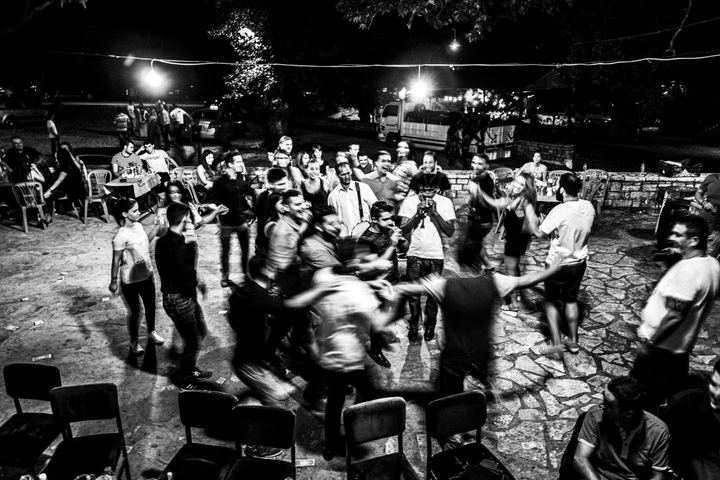Participants dancing in a circle at night in the monastery courtyard.