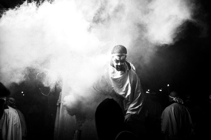 A Carnival performer emerging through smoke in Naxos Town.