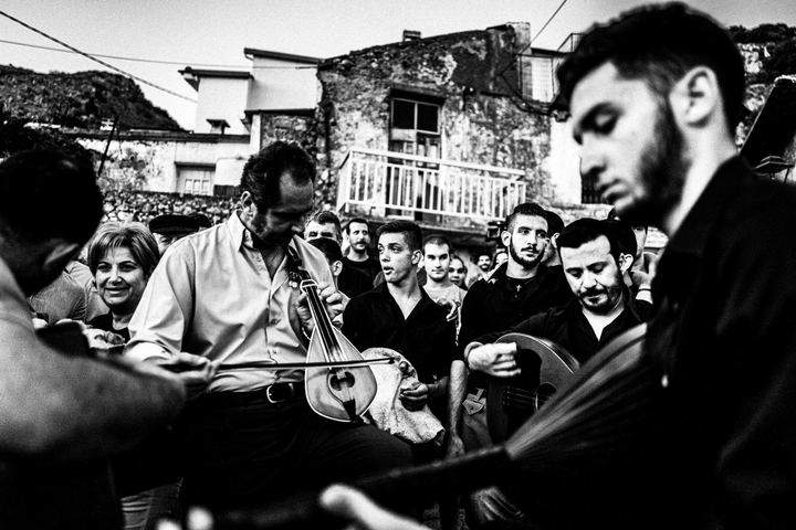 A Cretan singer surrounded by villagers during the Cantades.