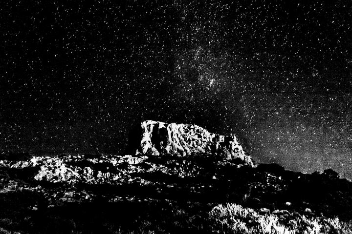 The chapel and mountain landscape beneath a star-filled sky.