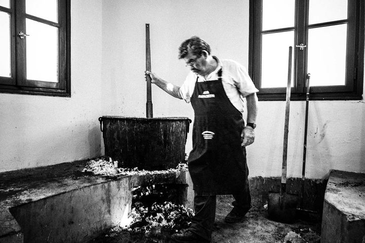A man stirring a casserole at Agia Paraskevi monastery in Amorgos
