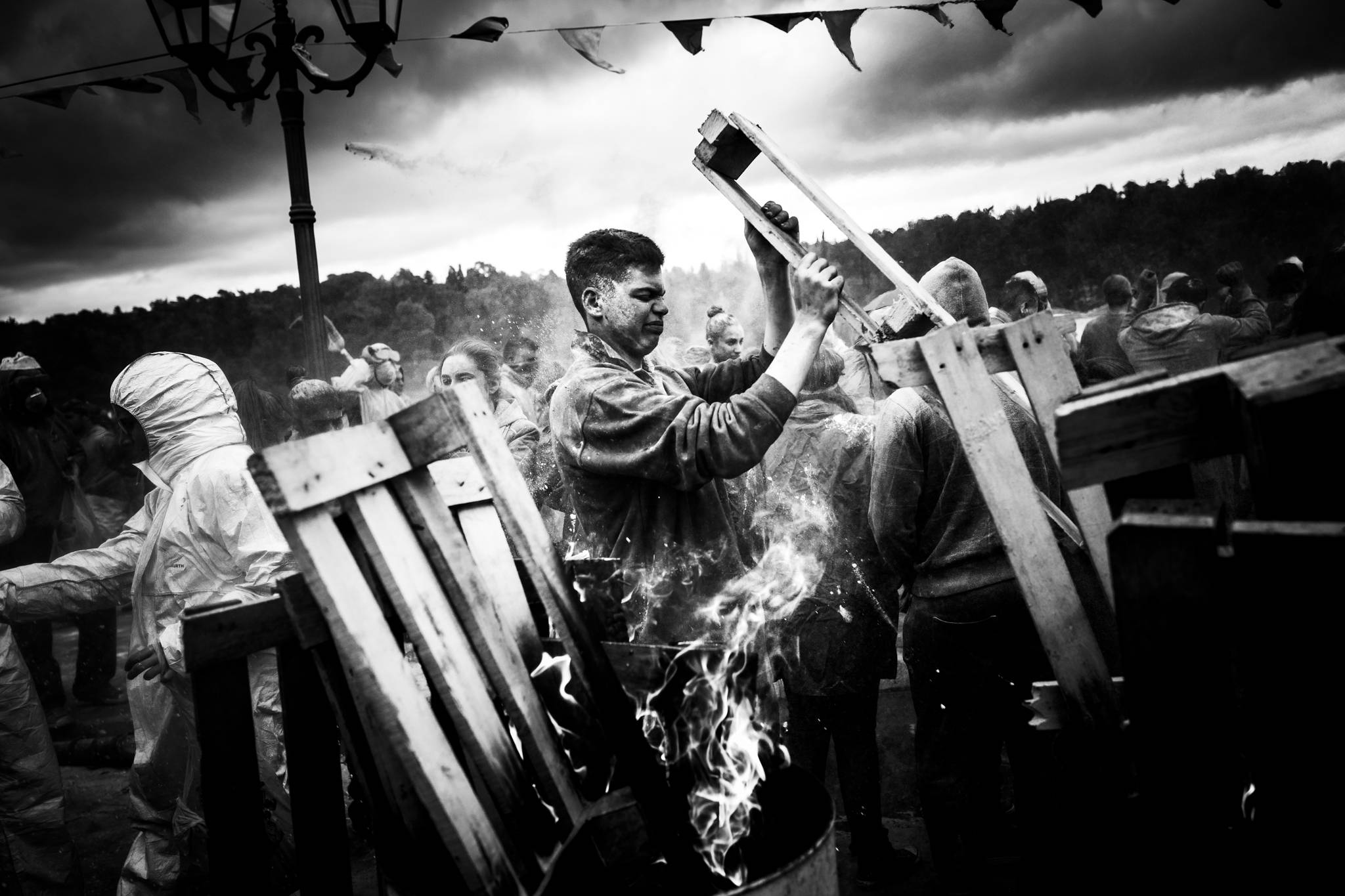A participant adding wood to a bonfire during Alevromountzouromata in Galaxidi.