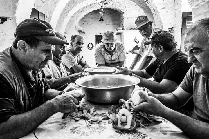 Volunteers peeling potatoes around a table before the feast.