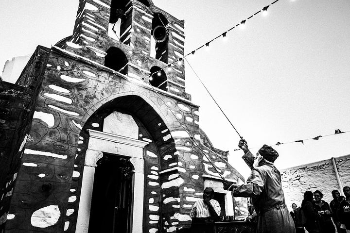 The priest sounding the church bell during the Feast of Prophet Elias on Sifnos