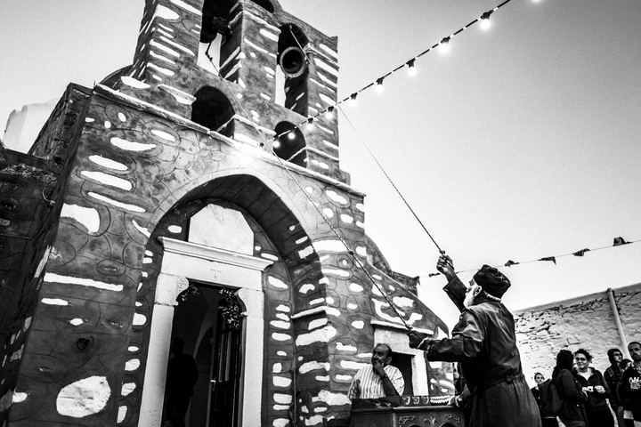 The priest sounding the church bell during the Feast of Prophet Elias on Sifnos