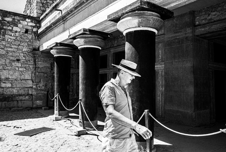 Black and white photograph of people moving through the archaeological site of Knossos in Crete.
