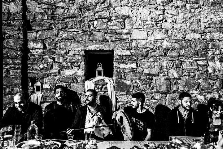 Black and white photograph of music and singing mantinades at a pre-wedding gathering in Anogia, Crete.
