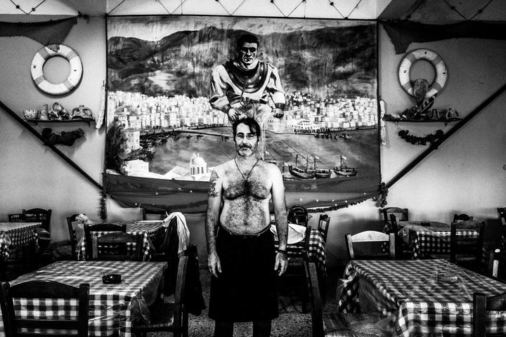 Nikitas, a taverna owner, poses inside his place "Omilos" on the island of Kalymnos
