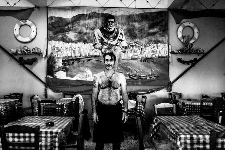 Nikitas, a taverna owner, poses inside his place "Omilos" on the island of Kalymnos