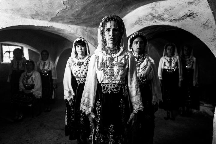 A group of women wearing the local costumes of Agia Anna, Euboea, inside an old local basement