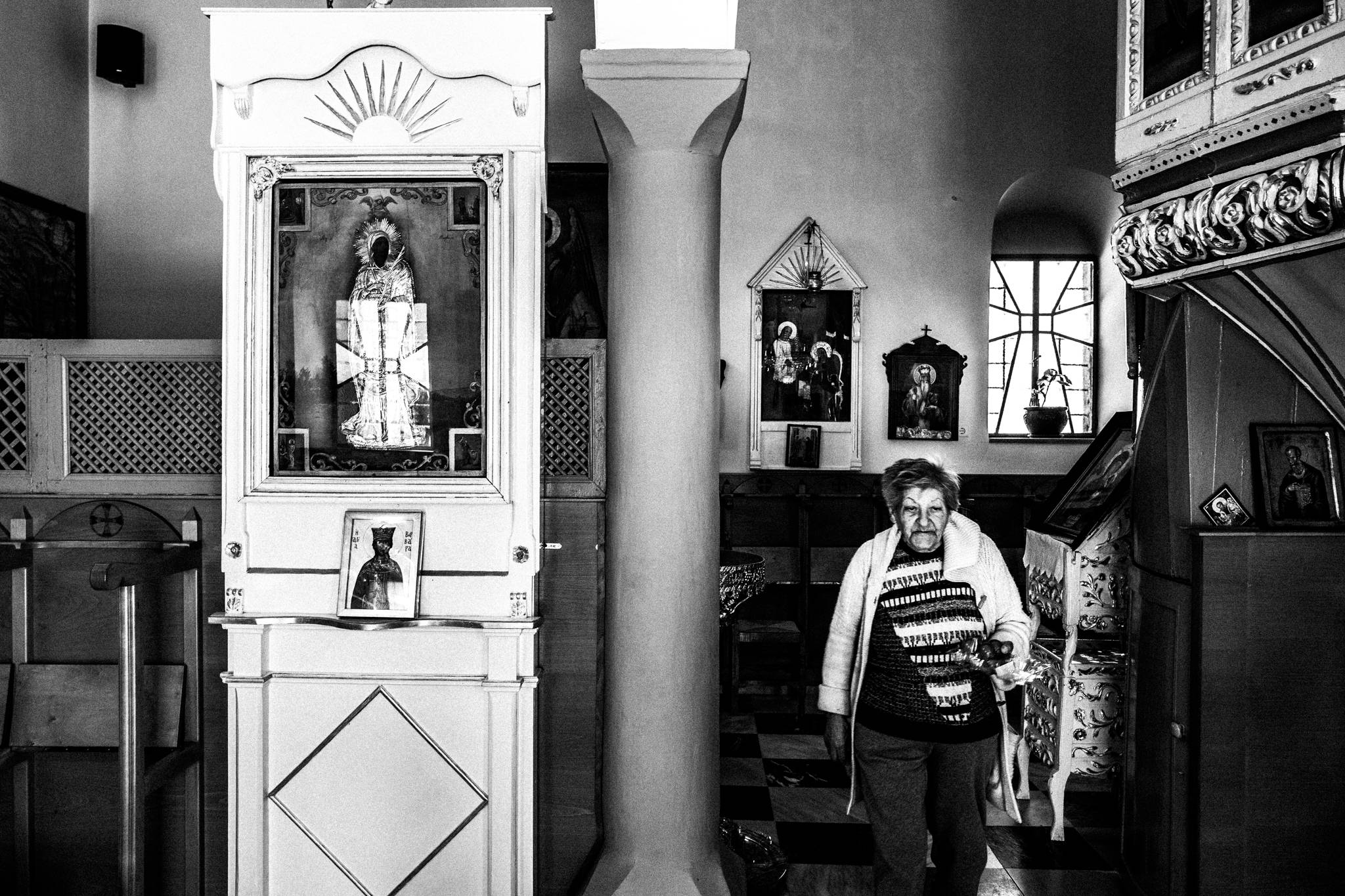 Black and white photograph of Smaragda Papastylianou inside the church of Taxiarches in Anavatos, Chios.