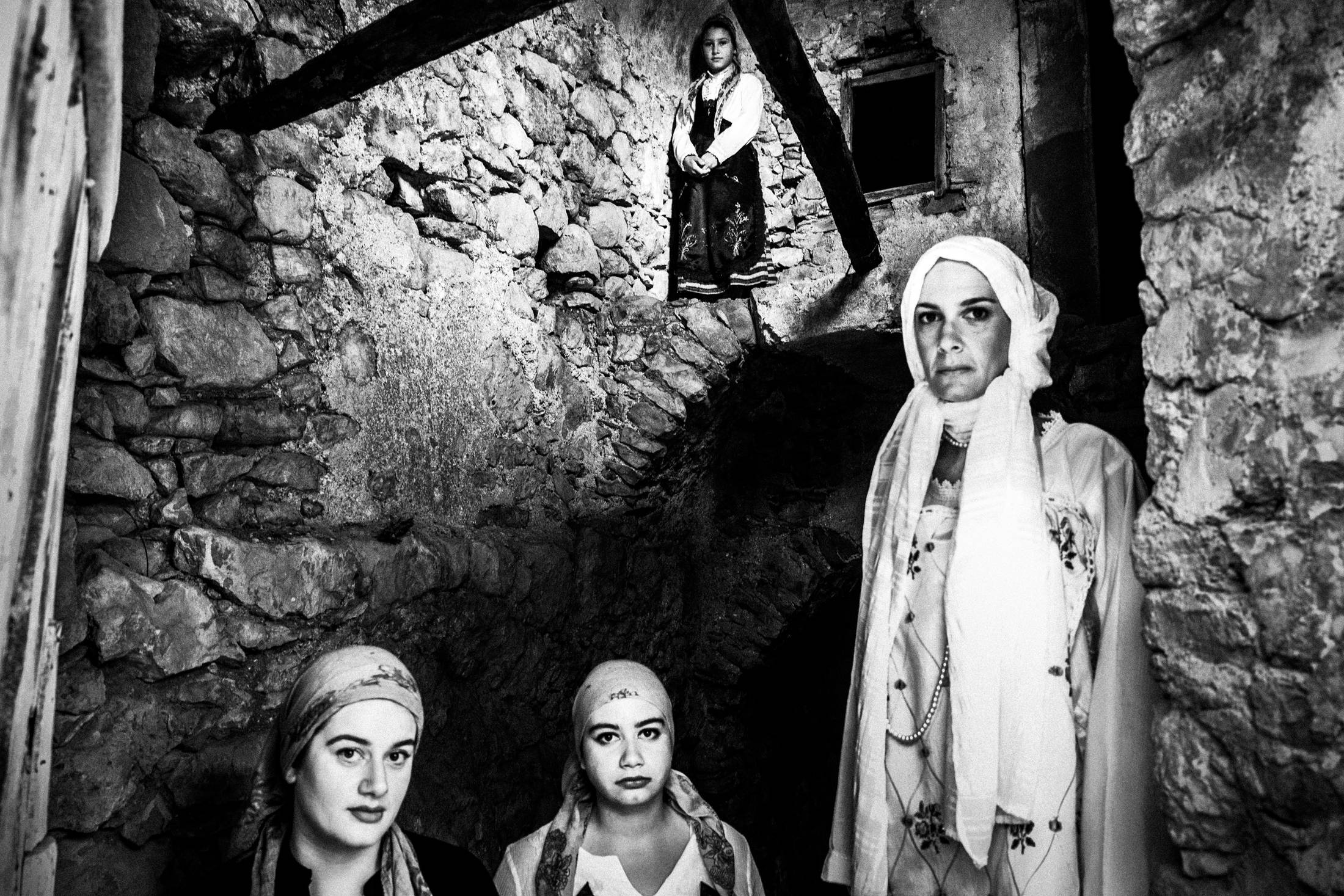 Women inside a local old stone building, wearing the costumes of Armolia, Chios