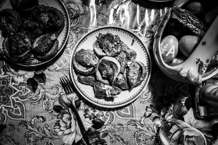 Black and white photograph of giaprakia served on plates beside dyed Easter eggs on a table in Patmos.