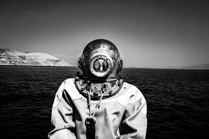 Dimitris wearing the old diving suit for sponges (skafandro) on a dock on the island of Kalymnos