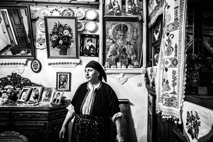 Black and white photograph of Kalliope, the local baker, inside her traditional home in Olympos, Karpathos.