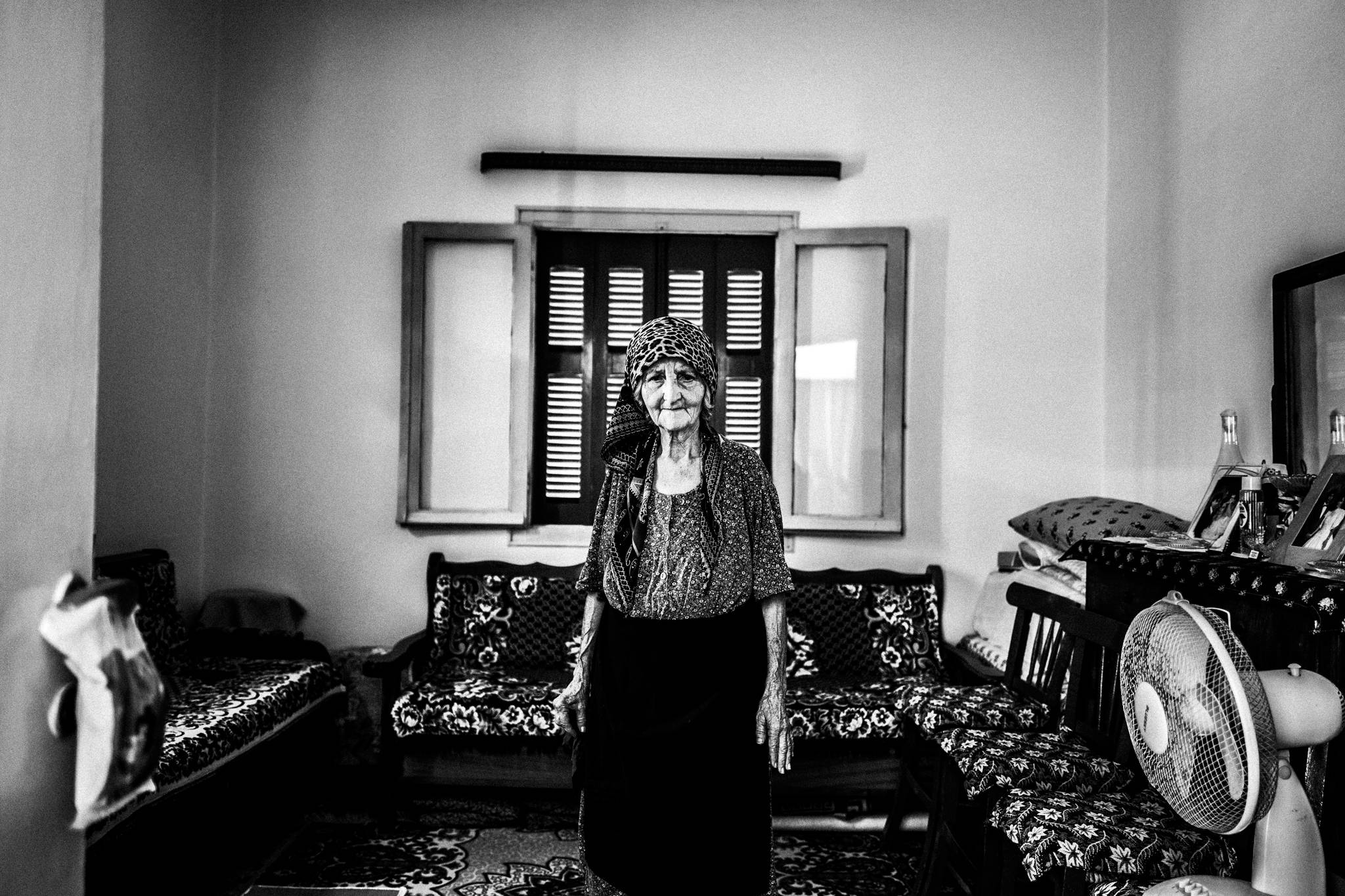 Hatice standing inside her traditionally furnished home in Platani, Kos