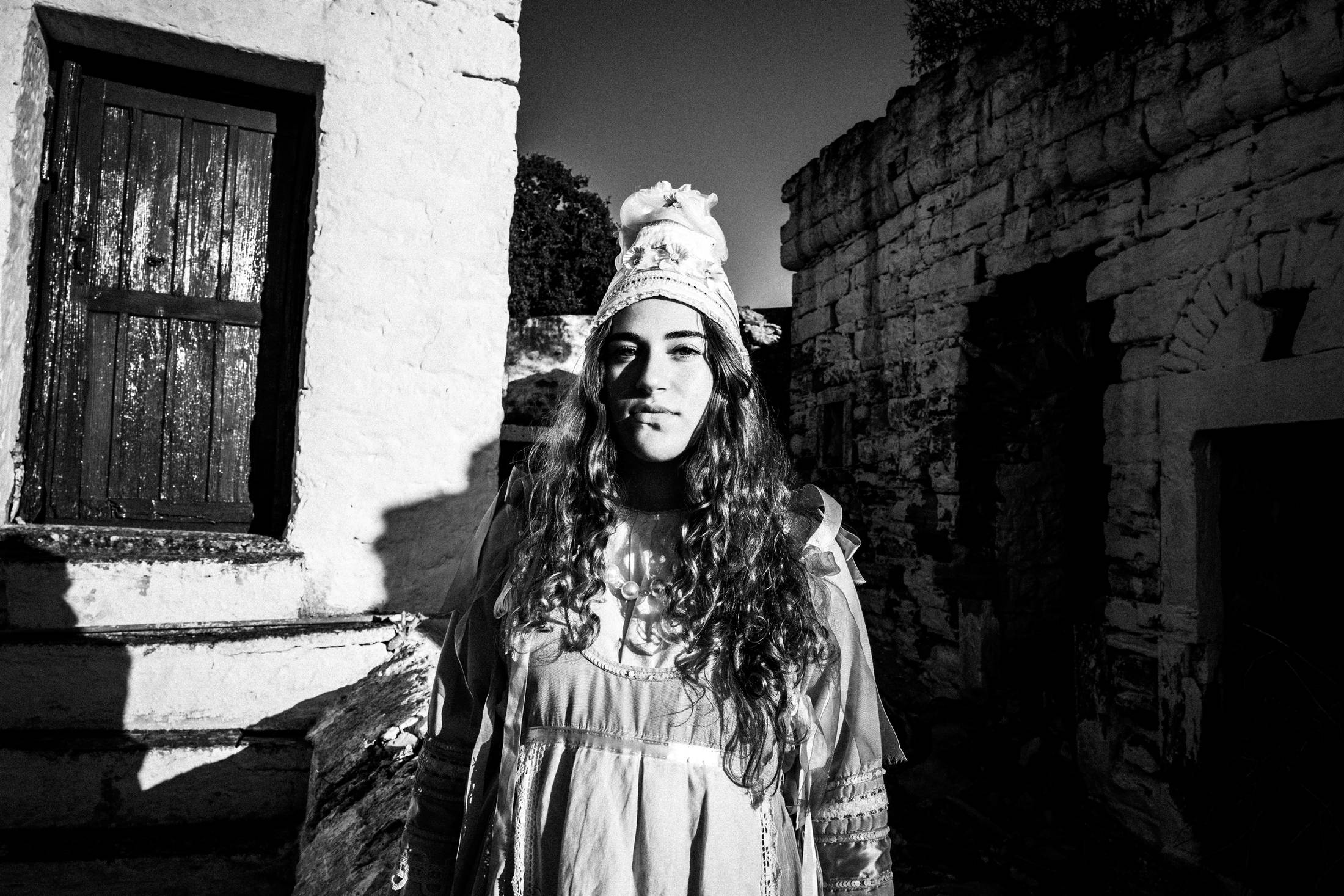 A young women is standing in the village of Thymiana for a close-up portrait on the island of Chios