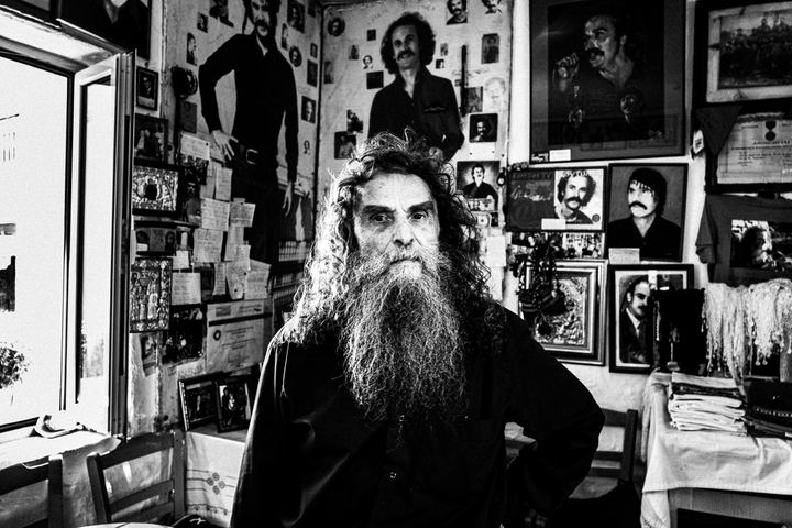 Black and white portrait of Psarantonis inside the former house of Nikos Xylouris in Anogia, Crete.