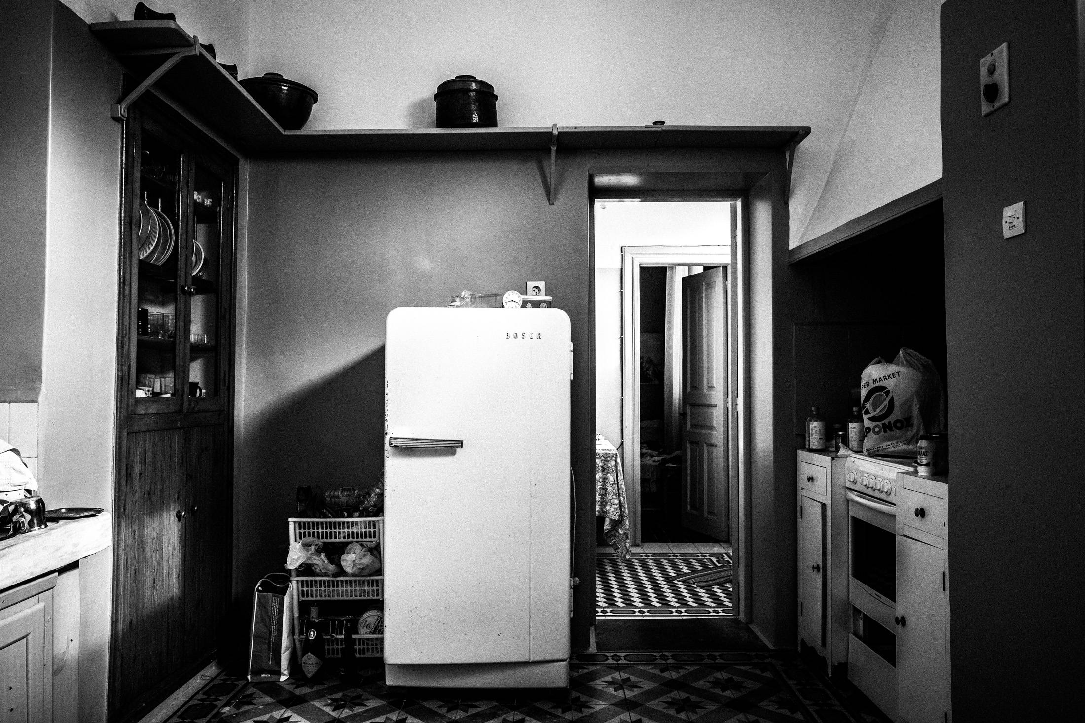Black and white photograph from inside a Kitro distillery in Naxos, with equipment and bottles visible.