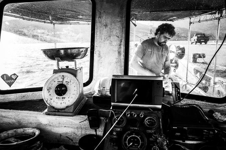 Black and white photograph of Pavlos preparing his fishing boat in Diafani, Karpathos.