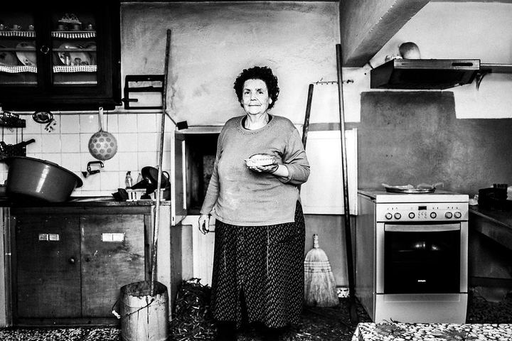 Black and white photograph of Moscha Gryllis holding a freshly baked Patiniotiki pie in Patmos.