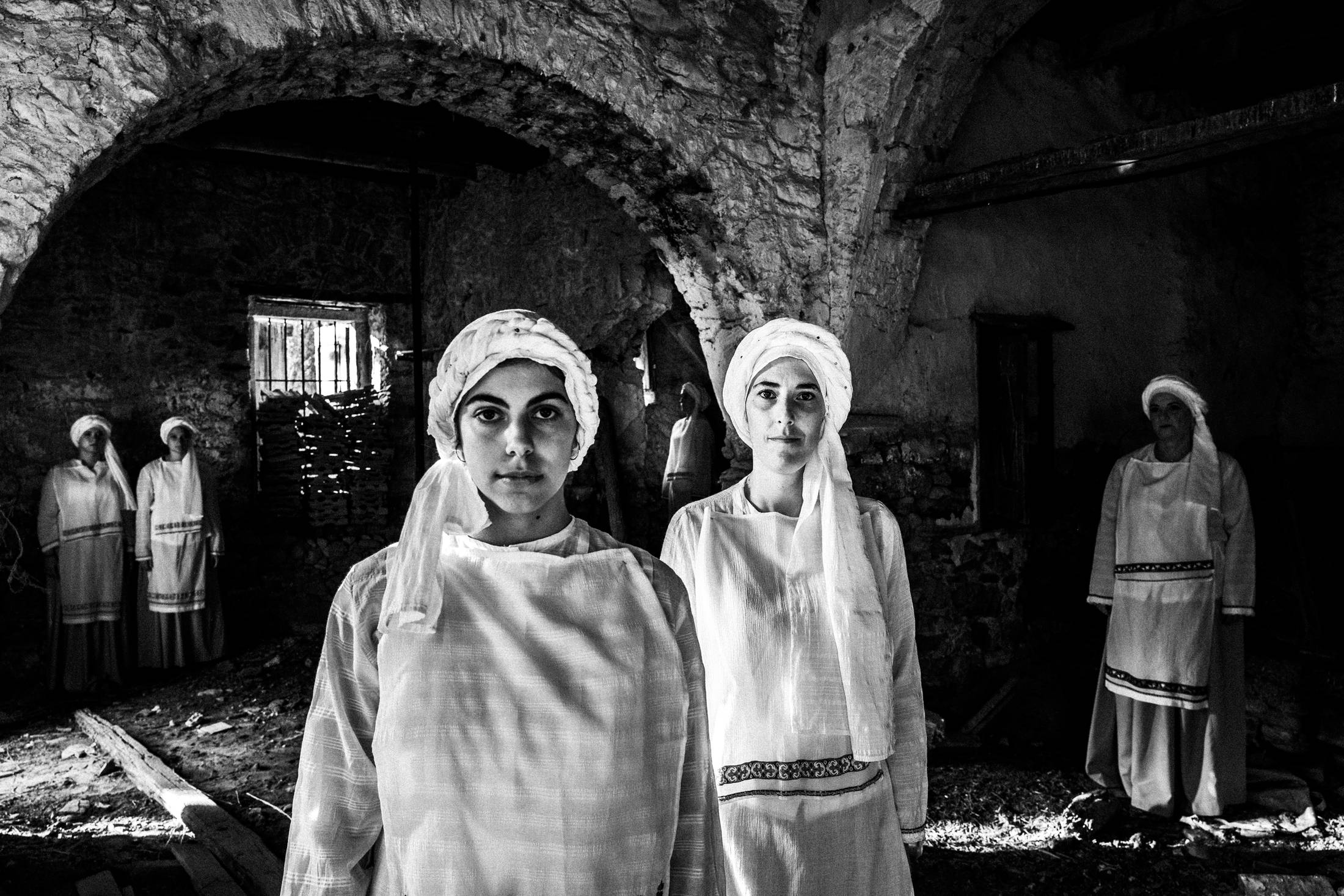 Women wearing the local dresses of Ververato inside an old mill