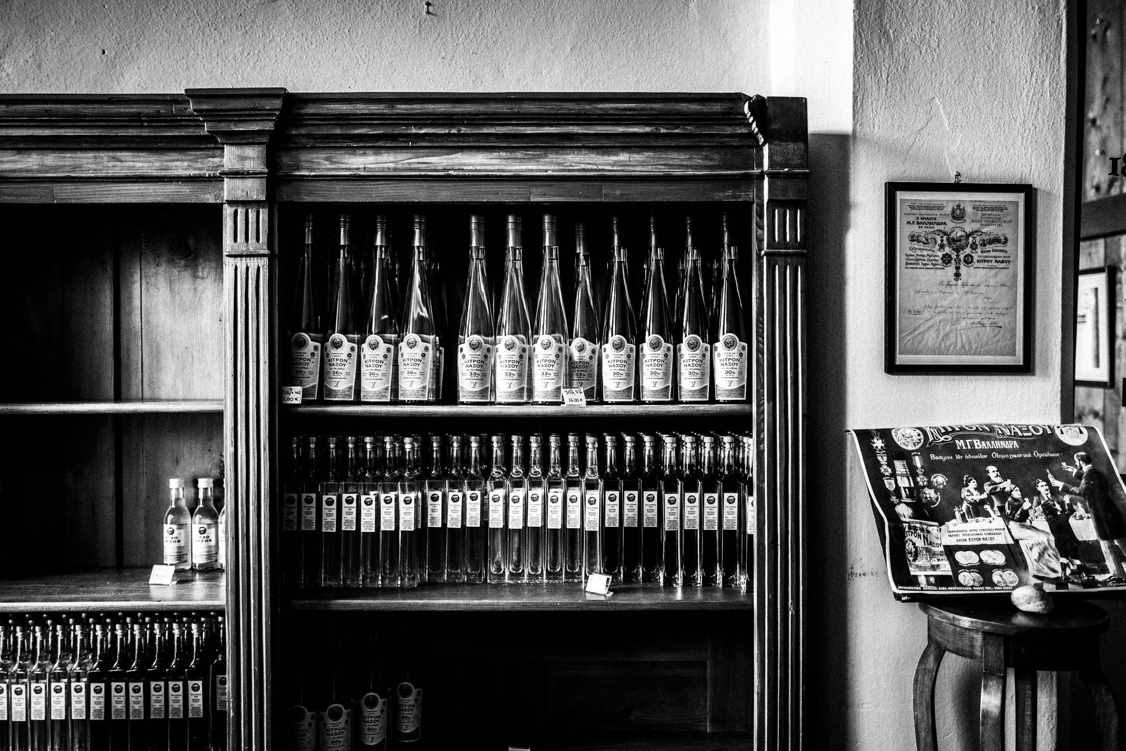 Black and white photograph of Kitron Naxou bottles displayed inside the distillery.