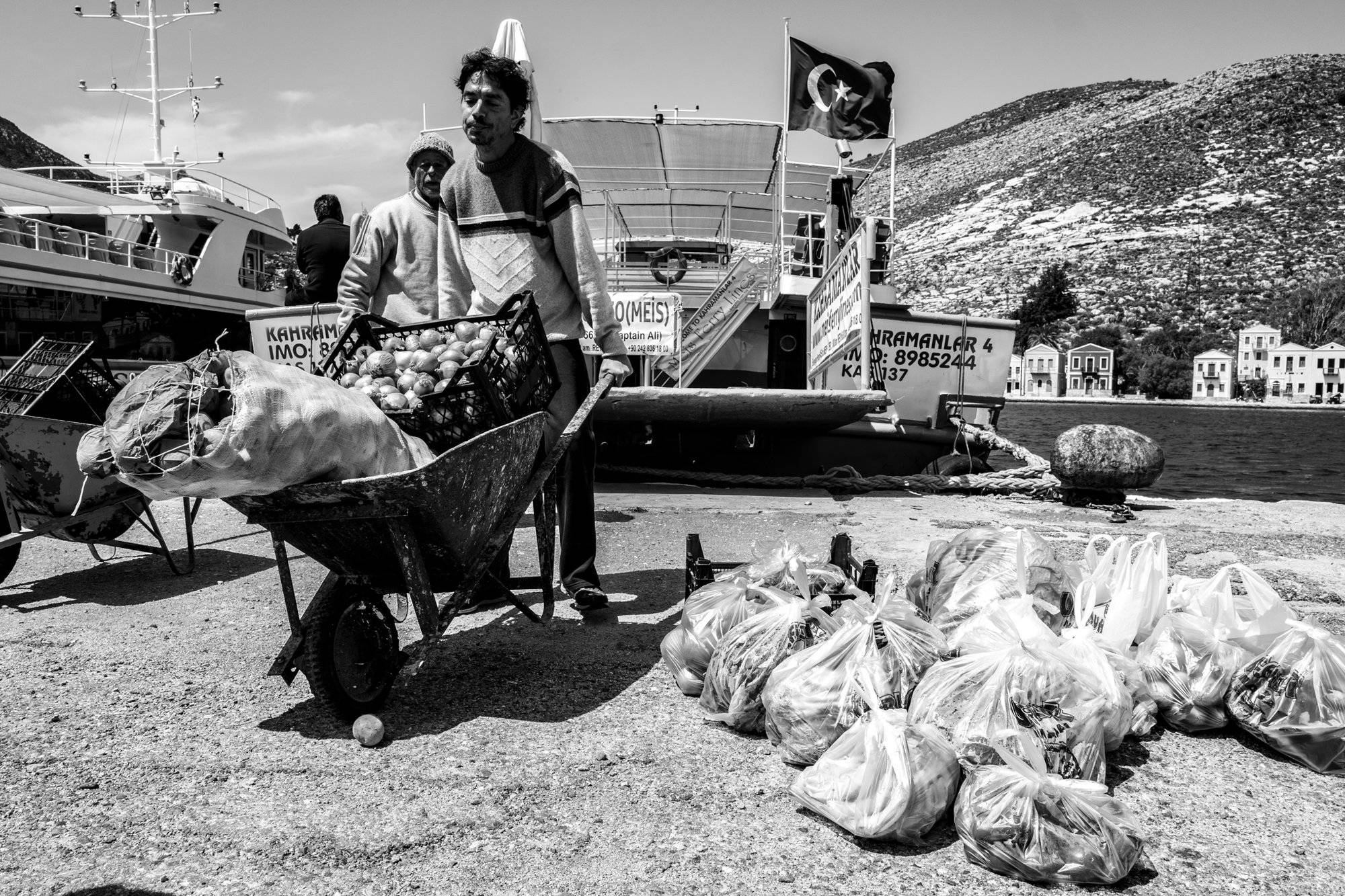 Black and white photograph of supplies arriving in Kastellorizo from the nearby Turkish town of Kaş.