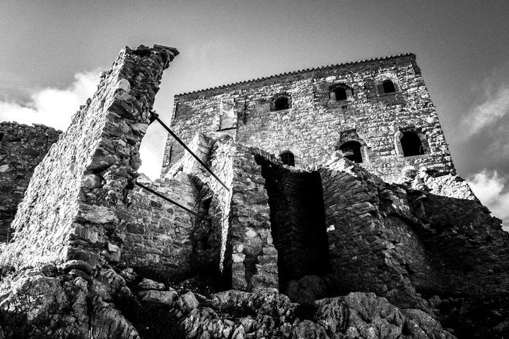 Black and white photograph of ruined stone houses and pathways in Anavatos, Chios.