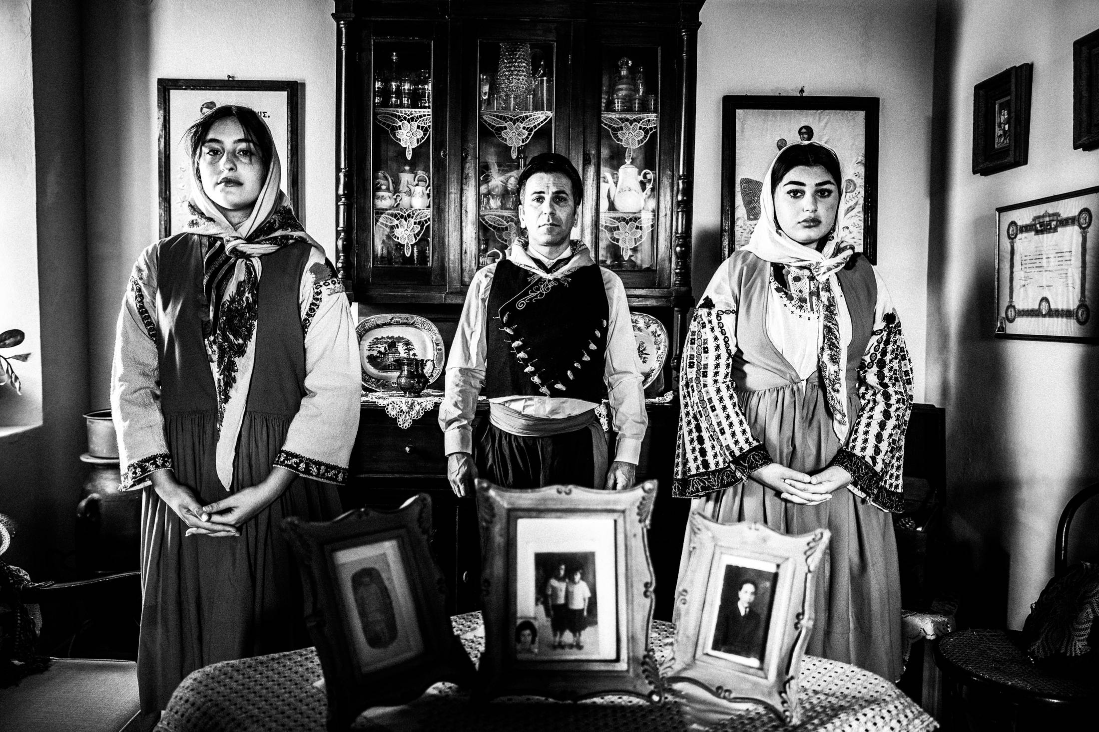 A man and two women wearing the costumes of Nisyros, inside a local house