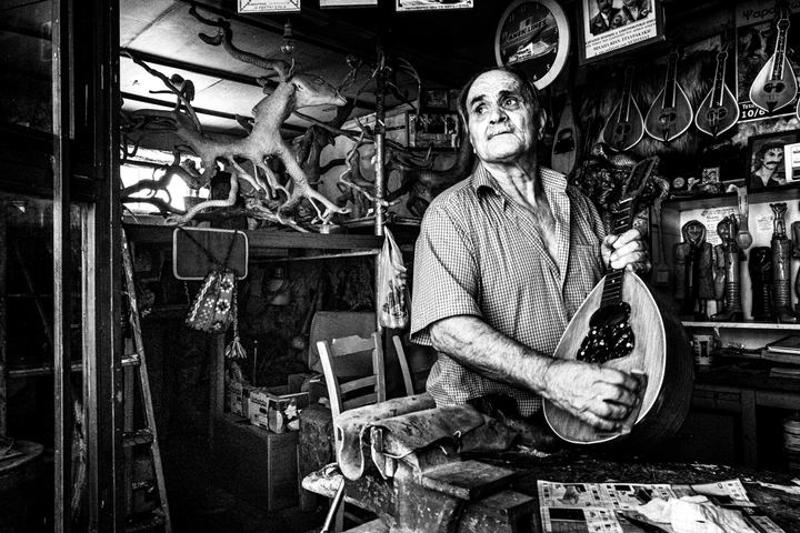 Black and white photograph of Stefanos Ploussis inside his workshop in Anogia, Crete.