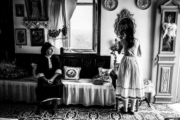 Black and white photograph of a bride-to-be preparing for her traditional engagement ceremony in Olympos, Karpathos.