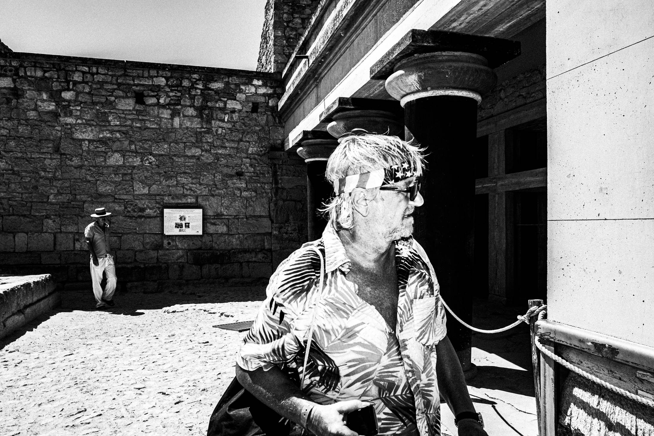 Black and white photograph of tourists visiting the archaeological site of Knossos in Heraklion, Crete.