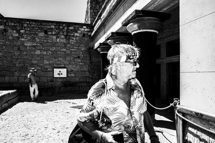 Black and white photograph of tourists visiting the archaeological site of Knossos in Heraklion, Crete.