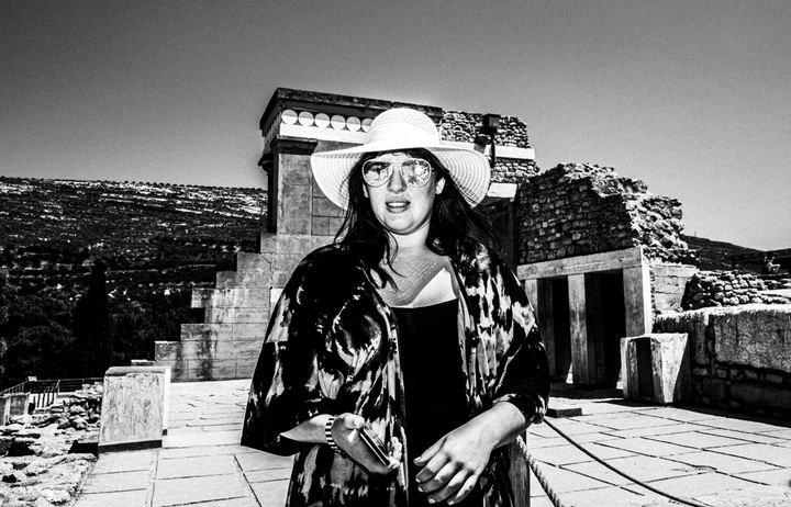Black and white photograph of a tourist walking around the ancient site of Knossos in Crete.