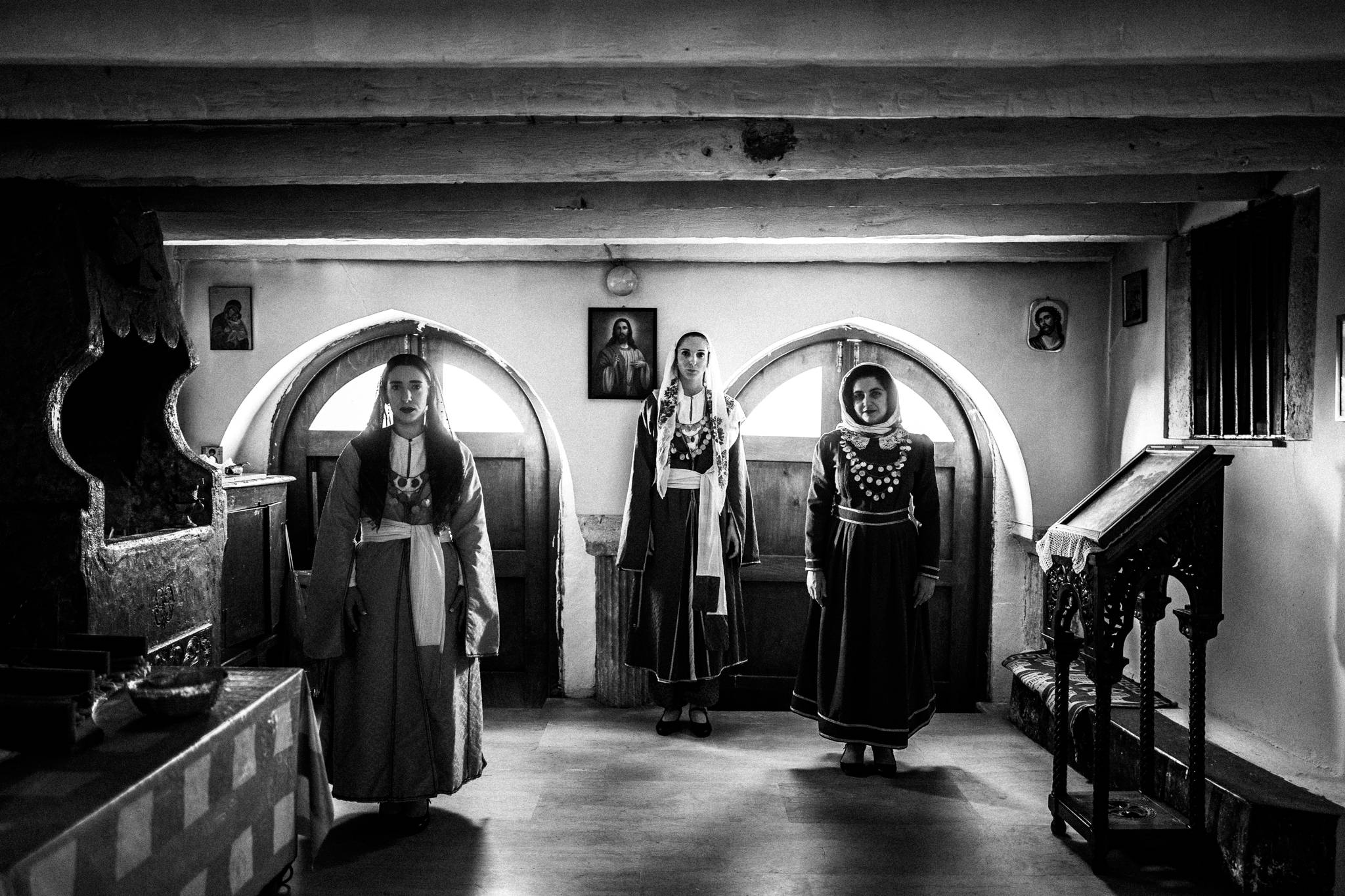 Three women in the traditional dresses of Kos, standing inside the church of St. Dimitrios in Chaichotes, Kos