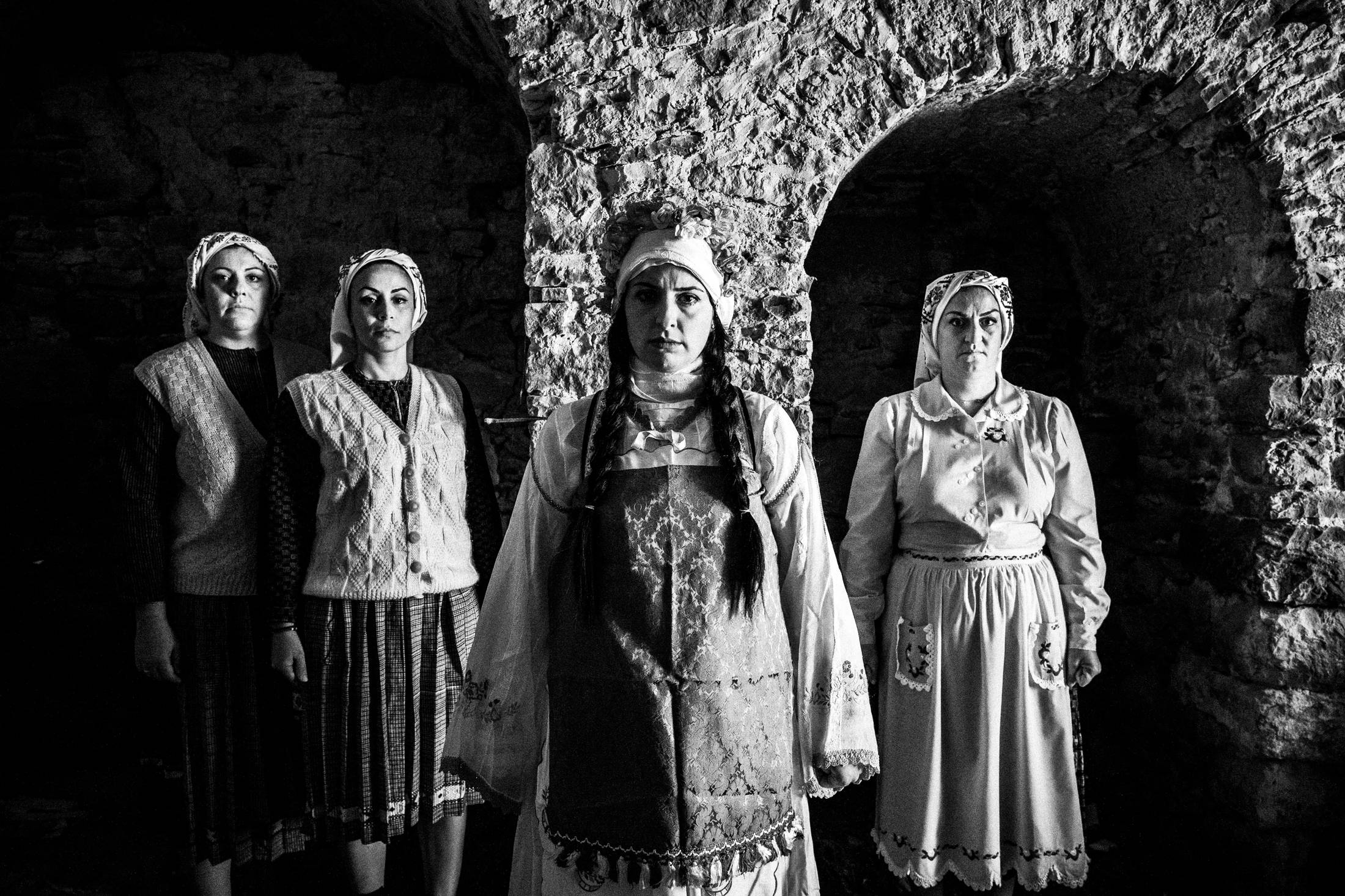 Four women inside an old local home at Mesta, Chios, wearing the local costumes.
