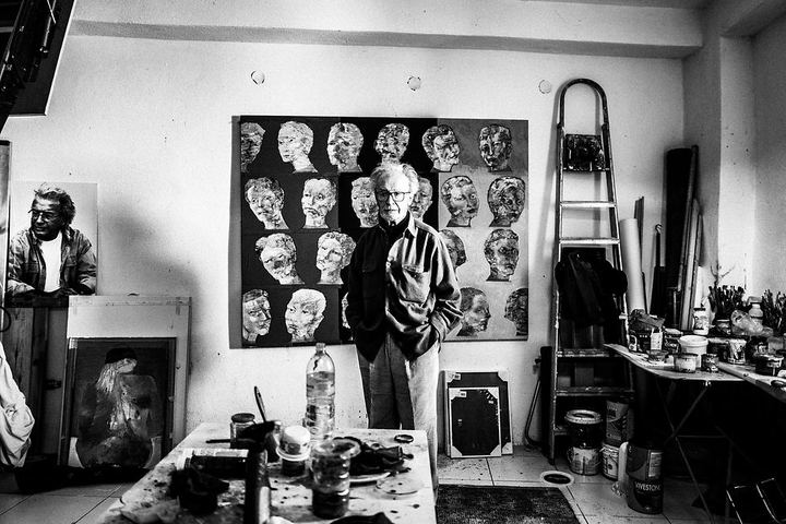 Black and white portrait of Vassilis Kypraios standing in his painting studio in Patmos.