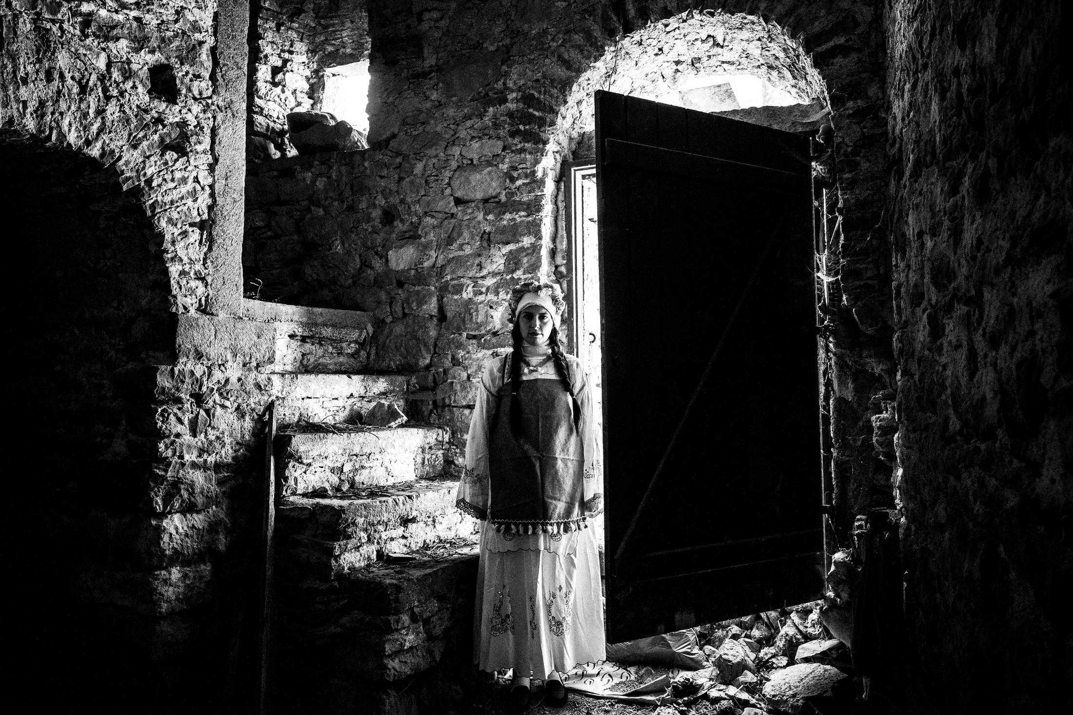 A woman inside an old local home at Mesta, Chios, wearing the local costumes.