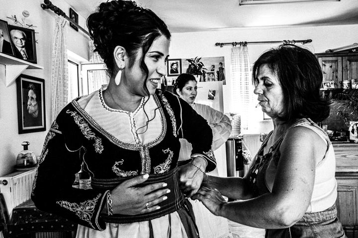 Black and white photograph of a friend of the bride getting ready before a wedding in Anogia, Crete.